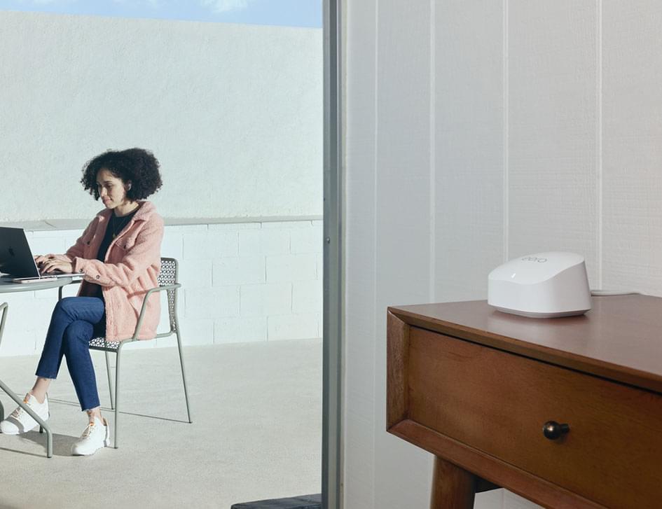 woman browsing the internet on her laptop while connected to an eero wifi pod